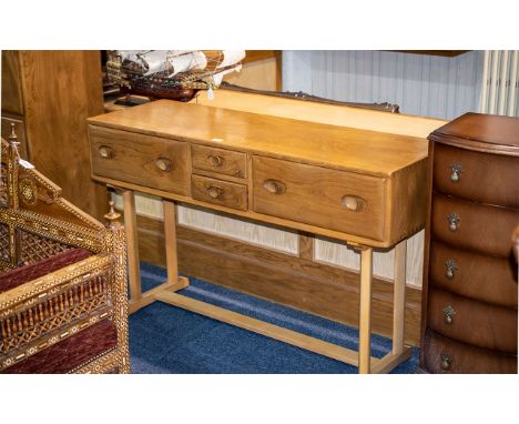 An Ercol Side Table With Two Central Short Drawers Between Two Large Drawers. Raised on two pairs of Chamfered supports, on a