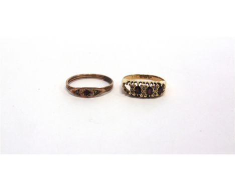 A GARNET 18 CARAT RING the oval cuts with rose cuts in between, one setting vacant, finger size M, 2.7g gross; with a wire sh