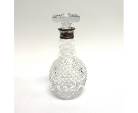 A GLASS DECANTER with silver rim by C.J. Vander, Birmingham 1995, the pineapple cut body to a ring neck, large button stopper