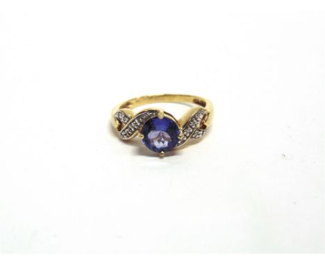 A TANZANITE AND DIAMOND 18 CARAT GOLD RING the round cut stone with single cut diamonds to each shoulder, finger size O, 3.6g