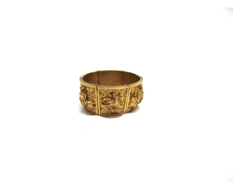 AN INDIAN GOLD CUFF BANGLE composed of six panels embossed in high relief with various deities, forward inner diameter 5.8cm,
