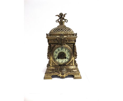 A CONTINENTAL GILT METAL MANTLE CLOCK  the case decorated with mask and surmounted by cherub, the 8-day movement striking on 