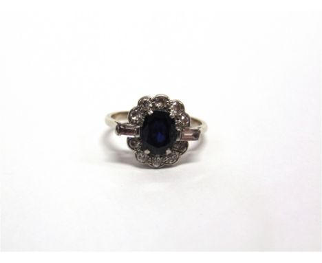 A DIAMOND AND SAPPHIRE CLUSTER RING the white mount unmarked, the oval cut stone measuring approximately 7.7mm by 5.5mm by 3.