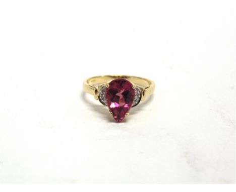 A PINK TOURMALINE AND DIAMOND 18 CARAT GOLD RING the pendeloque cut stone with a trio of single cuts to each shoulder, finger