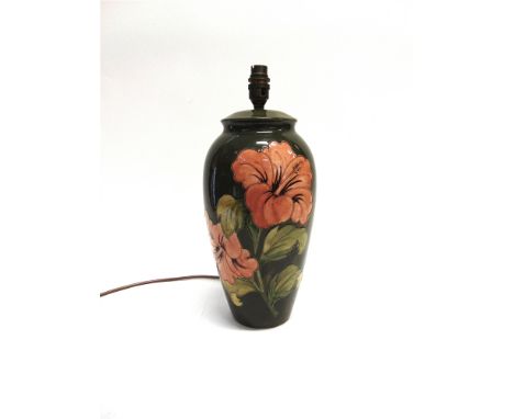 A LARGE MOORCROFT POTTERY TABLE LAMP  decorated in the 'Hibiscus' pattern on a green ground, 34cm high excluding electrical f