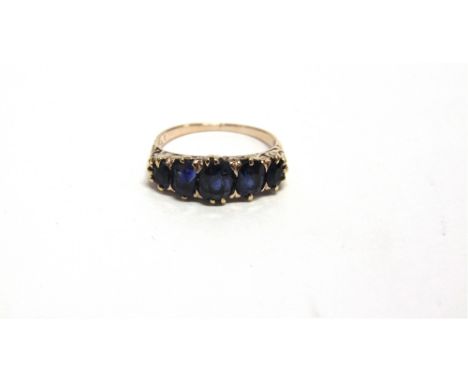 A FIVE STONE SAPPHIRE RING  the graduated oval cuts to a carved head mount, numbered 171, finger size O, 3.2g gross