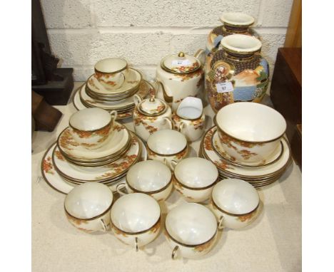 Thirty-four pieces of an Oriental export tea service decorated with autumnal leaves and a pair of modern Satsuma-style vases.