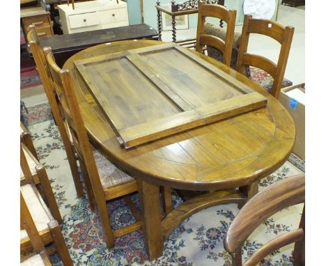 A Continental modern rustic 'distressed' wood draw-leaf oval table, on square legs united by stretchers, with two spare leave