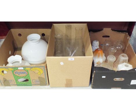 A collection of twelve various oil lamps and hanging light shades and a collection of glass oil lamp chimneys.