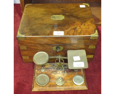 A late-Victorian walnut brass-bound writing box, 30cm wide and a set of brass postal scales and weights, (2).