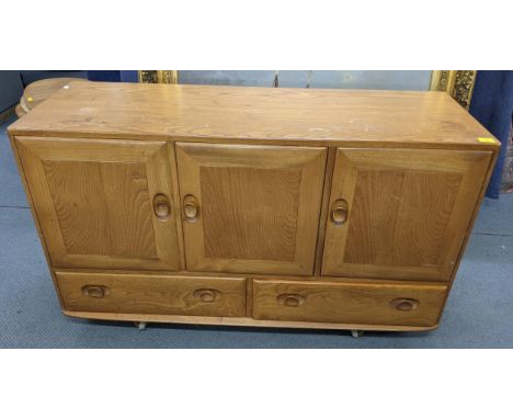 A mid 20th century Ercol blonde elm Windsor sideboard having three cupboard doors above two drawers, 77cm h x 129.5cm wLocati