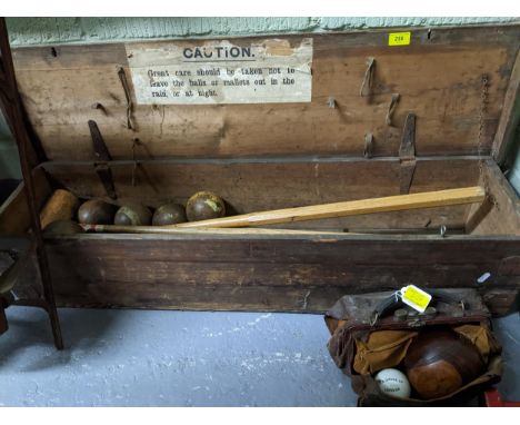 A wooden cased lawn croquet set comprising metal hoops, two wooden hammers, various wooden balls and pegs, and two wooden law