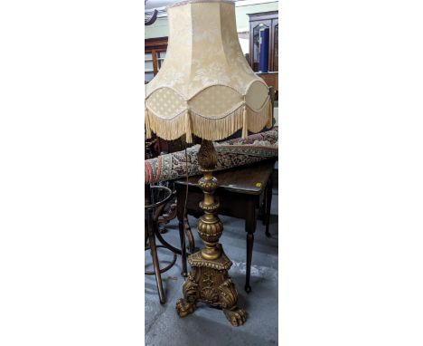 A 20th century gilt gesso wood standard lamp with moulded, fluted leaf and shell decoration, on three lion paw feet, with fab