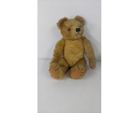 A 1930's Farnell teddy bear with gold coloured mohair, kapok stuffed, having amber and black glass eyes and webbed claws, Bri