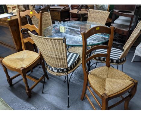 A mixed lot of furniture to include a glass topped garden table on a black finished metal base, along with four wicker and me