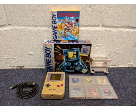 A Nintendo Game Boy compact video game system in original box along with six cased games - super Mario Land, Mickey Mouse, Ni