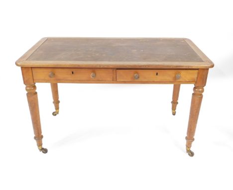 A Victorian satin birch writing table by Holland &amp; Sons, having top recess for a skiver, having two frieze drawers with b