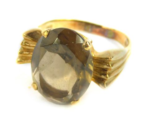 A 9ct gold and smokey quartz ring, claw set with channelled shoulders, size P/Q, 6.0g.