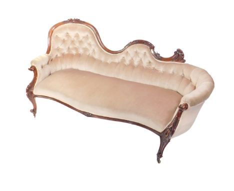 A Victorian walnut chaise lounge, with carved show frame, having a spoon back, scroll centre and curved return, scroll and fl