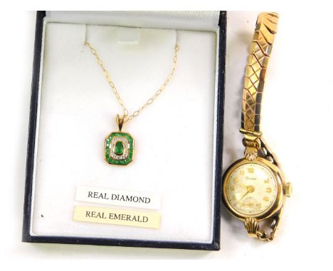 A gold emerald and diamond pendant on chain, the octagonal pendant set with an oval cut emerald in a surround of diamonds and