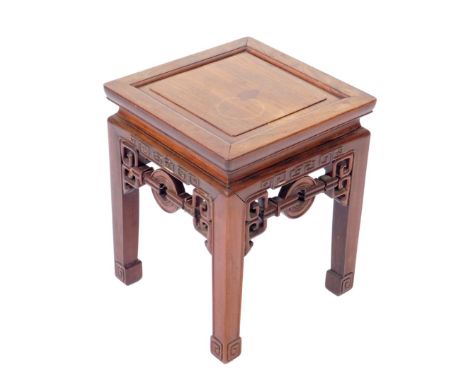 A Chinese hardwood urn stand, of square form, raised on square legs with fret work carving above scroll feet, 45cm H, 36cm W,