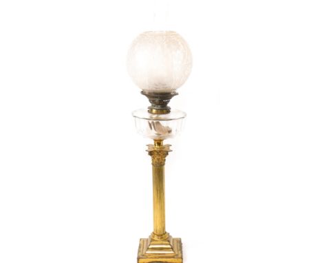 A late Victorian brass oil lamp, with Corinthian column, and stepped square base, having a clear slice cut glass reservoir tw