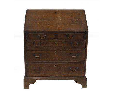 A George II oak bureau, with fall flap resting on lopers, revealing a fitted interior of drawers and pigeon holes, over two s