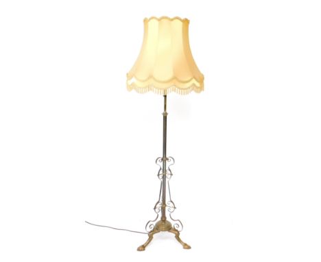 A Victorian brass telescopic standard lamp, with scrolling supports, raised on a circular base and three cabriole legs, 176cm