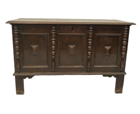 An early 18thC oak coffer, with plain moulded top and three panel front with applied turned columns dividing panels with fiel