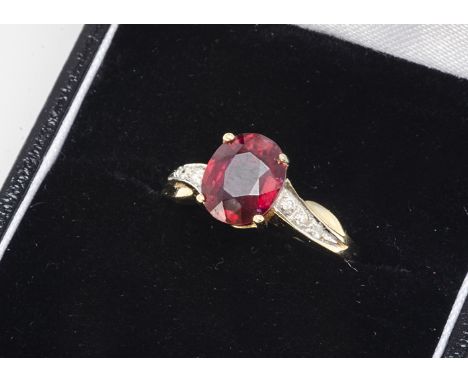 An 18ct gold ruby and diamond dress ring, the oval mixed cut in four claw setting with diamond set brilliant cut shoulders in