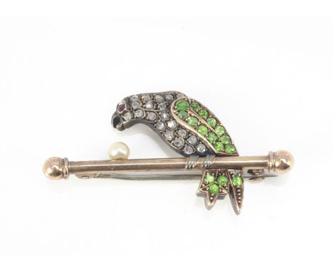 An early 20th Century platinum and gold diamond, ruby and demantoid garnet set parrot brooch, with encrusted body and wings o