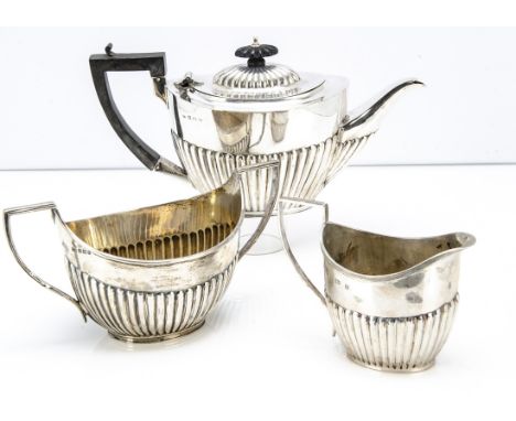 An Edwardian and later associated three piece tea set, with teapot, large sugar basin and milk jug, all helmet shaped with fl