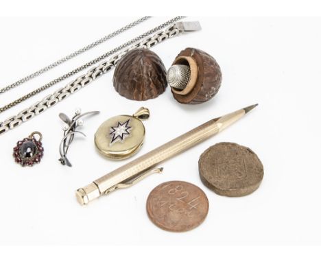 A boxwood walnut thimble case, a gold plated seed pearl and enamel locket, 4.5cm x 3cm, a foil backed garnet oval drop, gold 
