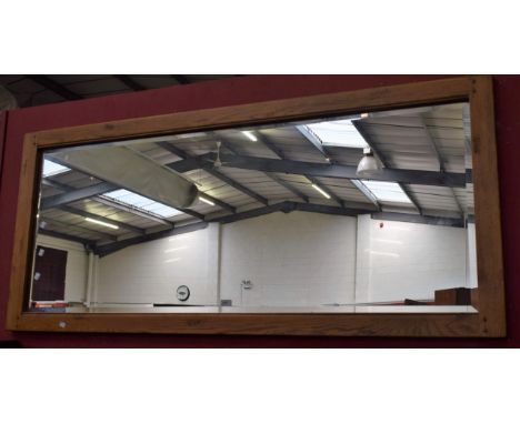 A large light oak framed wall mirror, bevelled plate, 175cm x 77cm