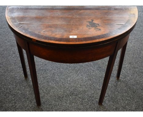 A George III crossbanded mahogany card table, the hinged top enclosing a baize lined playing surface, tapered square legs, 86