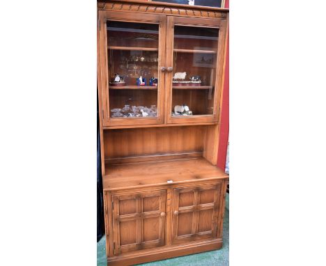 An Ercol bookcase, glazed doors enclosing adjustable shelves above a pair of cupboard doors, 196.5cm high