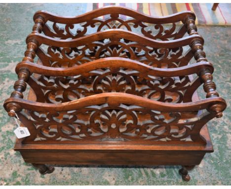 A Victorian walnut Canterbury, shaped and pierced dividers, turned legs, ceramic casters, c1860