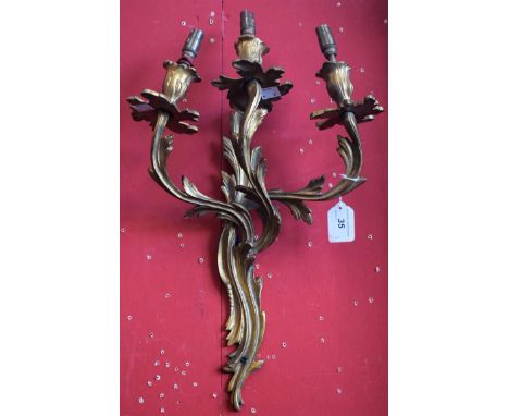 A pair of Rococo Revival ormolu three-light wall sconces, cast throughout with acanthus, 45cm long
