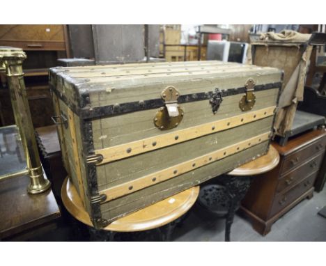 A WOODEN AND LEATHERETTE COVERED TRAVELLING TRUNK 