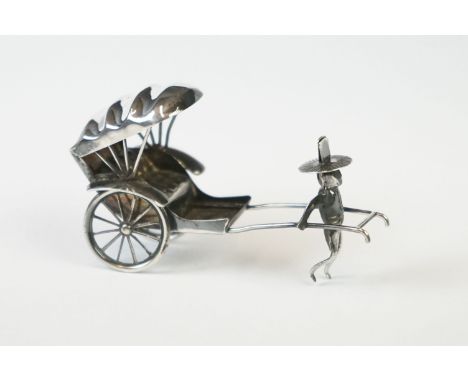 A Chinese sterling silver ornament of a man pulling a rickshaw. 