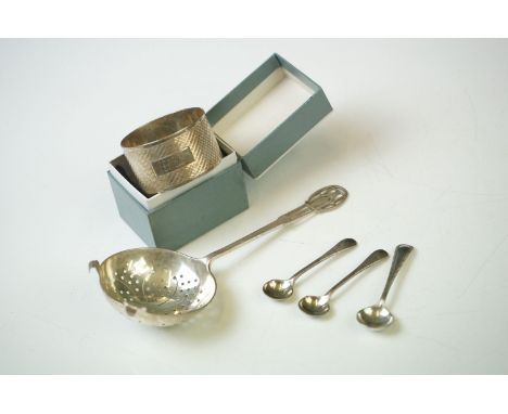 A small collection of hallmarked sterling silver to include a tea strainer, napkin ring and three salt spoons. 