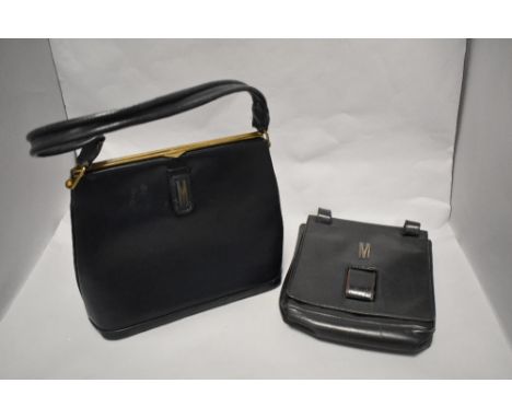 Two vintage leather handbags, both monogrammed with 'M', one 1950s black clutch bag with unusual fastening and integrated pur