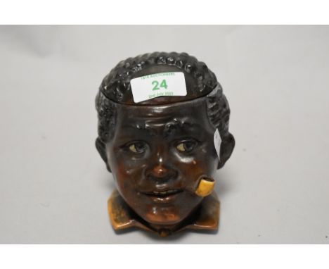 A novelty pottery tobacco jar, modelled as a Blackamoor smoking a pipe, 12cm tall