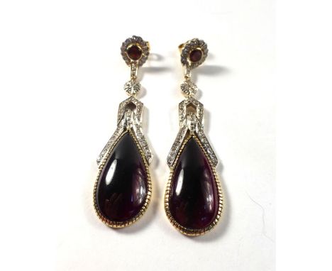 A pair of 14ct yellow gold and platinum highlighted ear pendants, the stud sections each set a circular garnet in a surround 