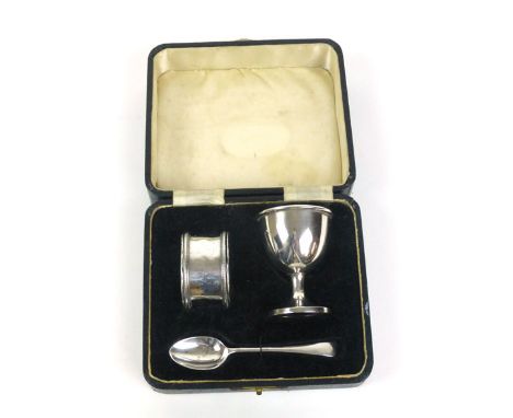 A cased silver christening set, to include egg cup, spoon and napkin ring, w. 48 grams approx