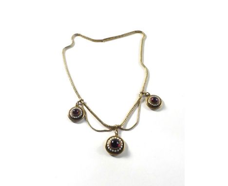 A 19th century yellow gold Etruscan style snakelink necklace suspending three graduated pendants of target form, each set gar