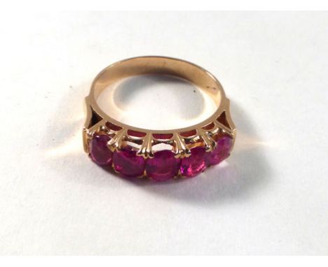 A yellow gold ring set five slightly graduated rubies in a raised setting, estimated total ruby weight approximately 1.75 car
