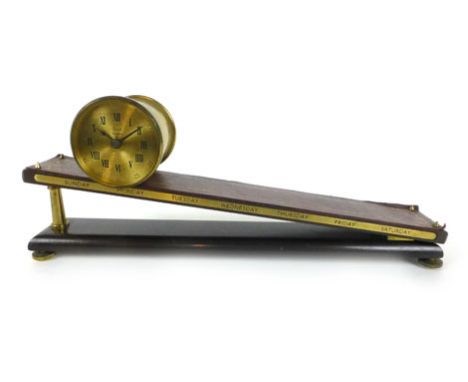 A gravity clock by Dent of London, the brass cylindrical timepiece with Roman numerals and marked 'Dent, London', on a tooled