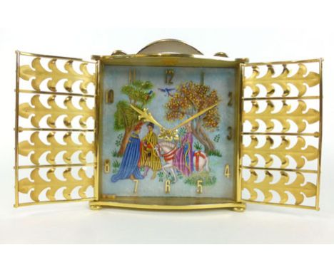A 1970's brass cased mantle clock with foliate grill doors opening to reveal an enamelled face with medieval scene and applie