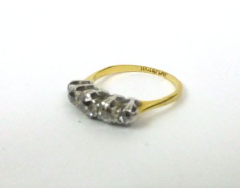 An 18ct yellow gold ring set five graduated old cut diamonds within a raised platinum setting, central stone approx. 0.25 car